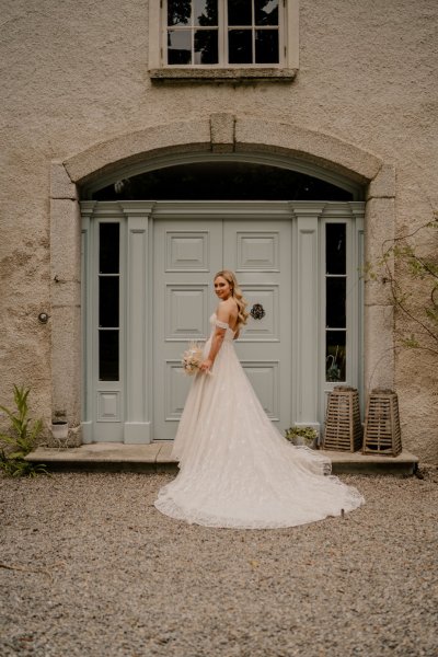 Bride white long dress train outside exterior wedding venue