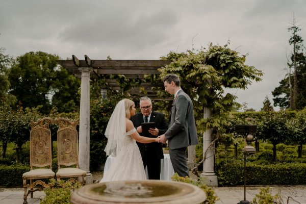 ceremony reading Bride officiant exterior wedding holding hands