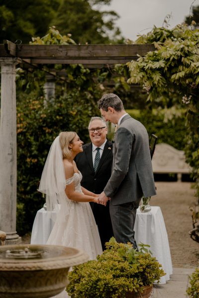 Bride officiant exterior wedding holding hands