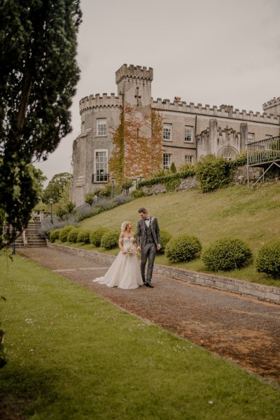 Couple after wedding ceremony bride groom bouquet flowers manor castle in background forest park