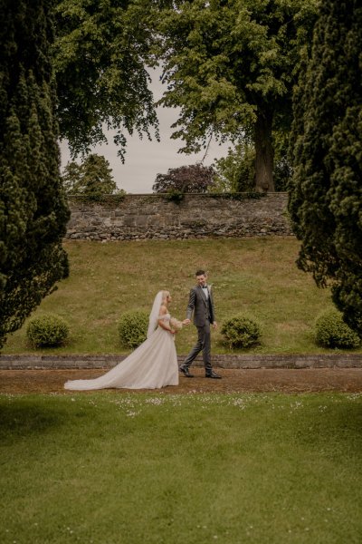 Couple after wedding ceremony bride groom bouquet flowers manor castle in background forest park