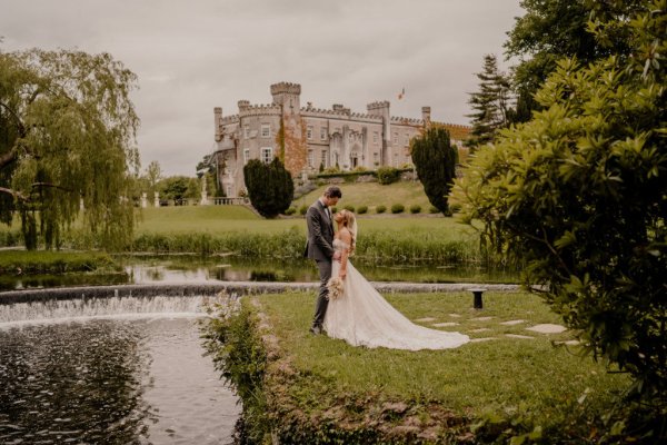 Couple after wedding ceremony bride groom bouquet flowers manor castle in background forest park