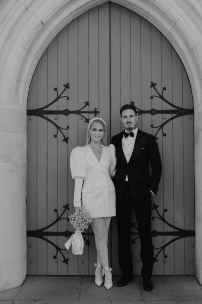 Wedding couple outside church venue short wedding dress bride and groom close up flowers bouquet