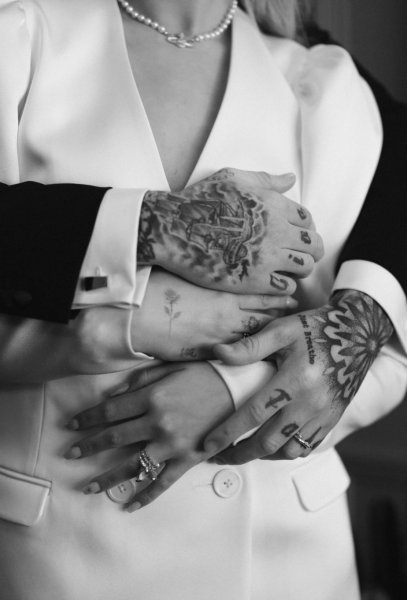 Grooms tattooed arms wrapped around bride tattoos