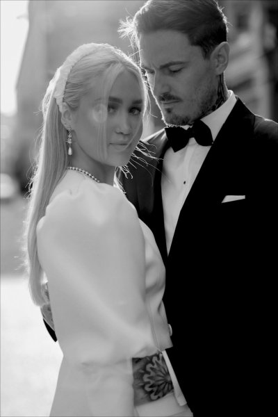 Bride and groom pose outside with sun shining