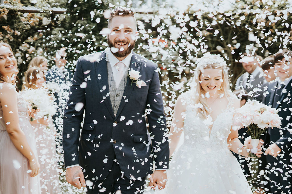 Confetti on bride and groom suit walking out of wedding