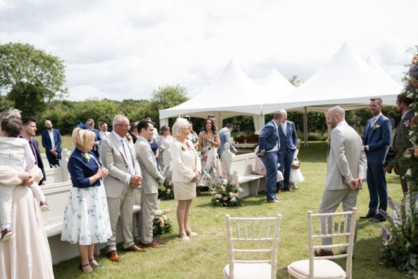 Guests watching grooms during wedding ceremony