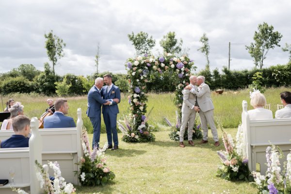 Grooms hug fathers wedding ceremony