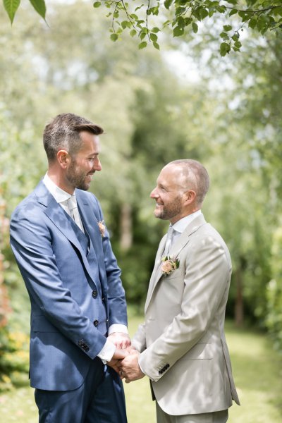 Grooms hand in hand in forest farm garden