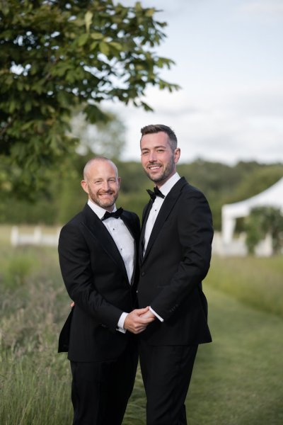 Grooms wearing black suit and tie garden