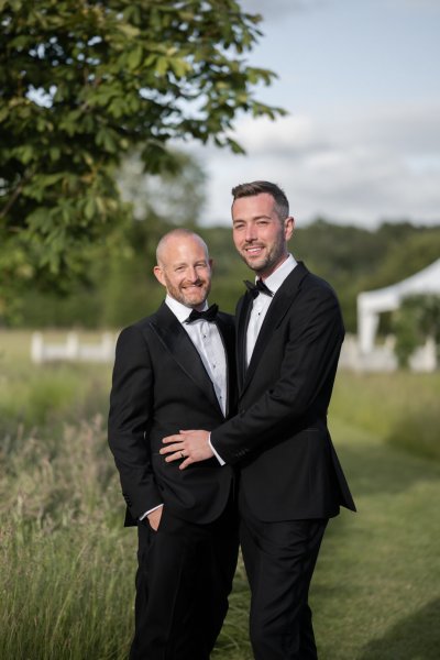 Grooms wearing black suit and tie garden