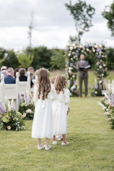 Little flower girl walking up aisle field