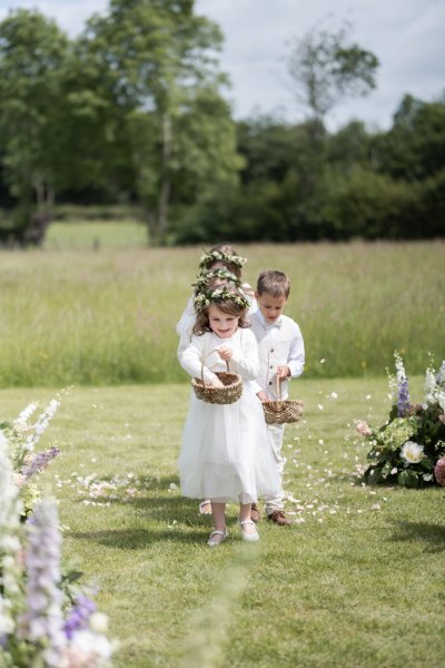 Little flower girl walking up aisle field