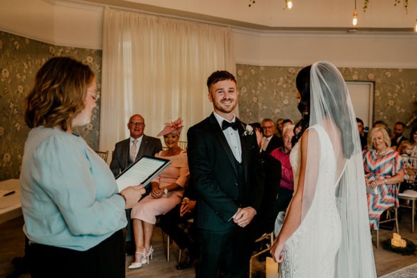 Bride and groom in front of family members with officiant