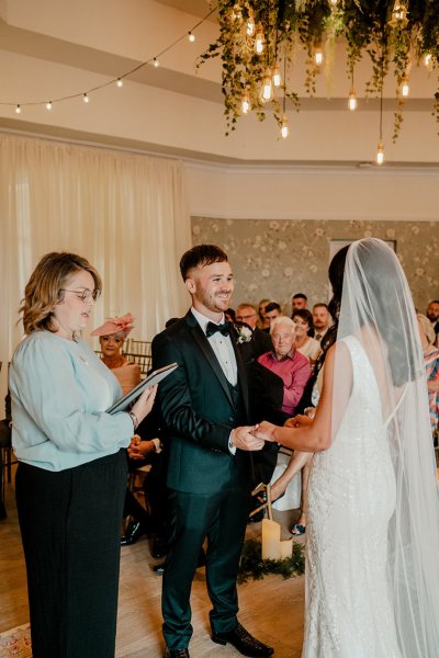 Bride and groom in front of family members with officiant