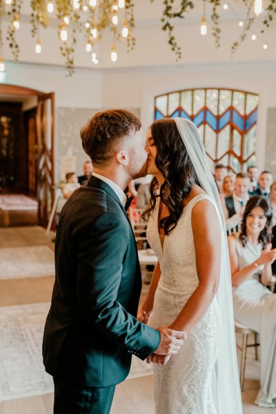 Bride and groom kiss during wedding ceremony