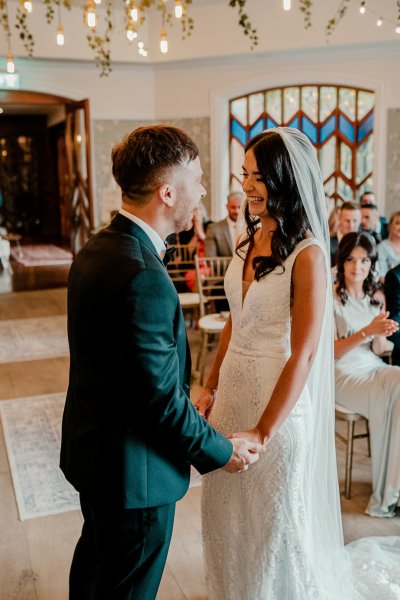 Bride and groom hand in hand holding hands during wedding ceremony