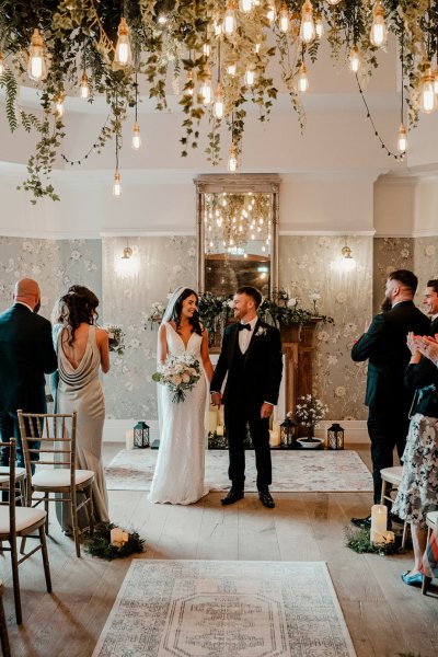 Bride and groom at alter in front of family members