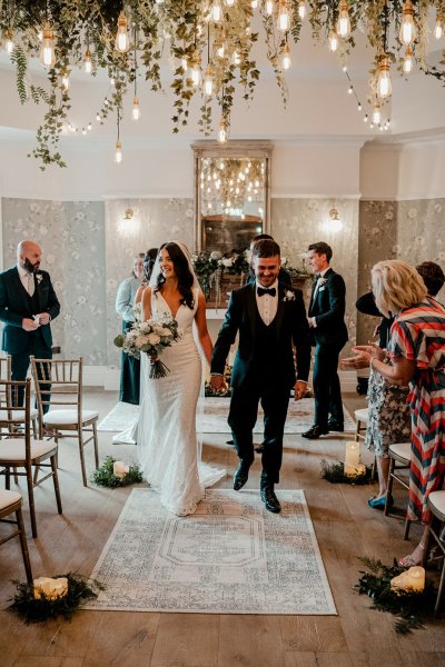 Bride and groom exiting wedding ceremony guests clapping