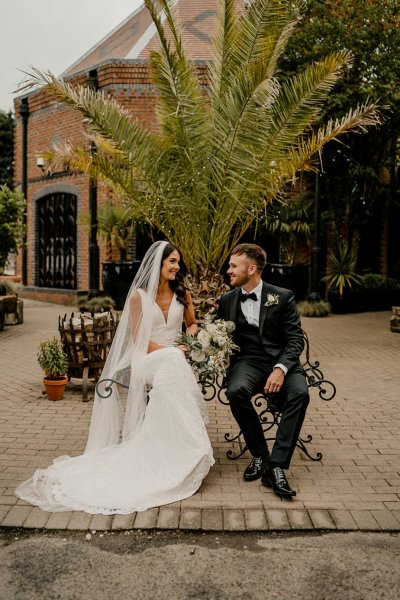 Bride and groom sitting on bench