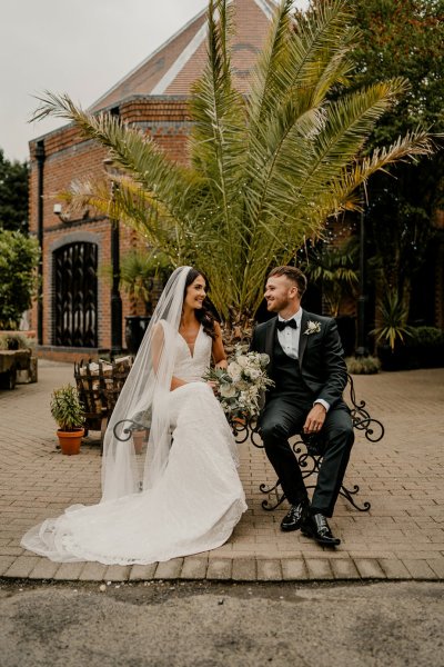 Bride and groom sitting on bench