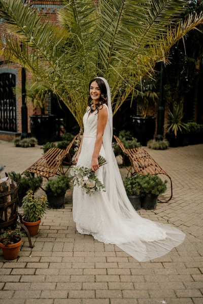 Tree in background bride on her own flowers by her side