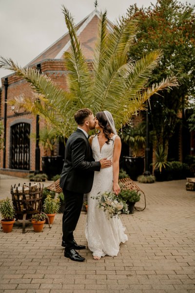 Bride and groom kiss exterior