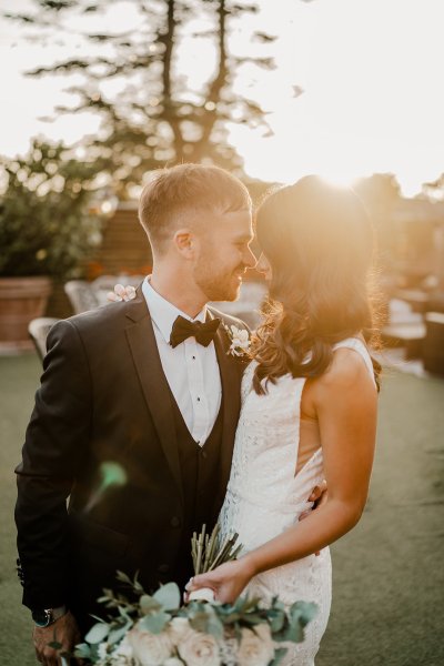 Bride and groom looking at each other sunset in background