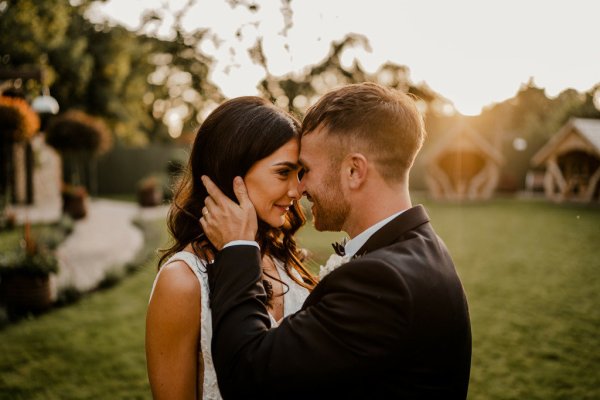 Groom places forehead on brides embrace