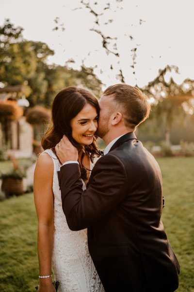 Groom kisses bride on cheek