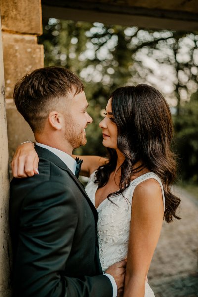 Bride and groom look at each other smile