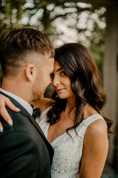 Bride smiles at camera while groom looks at her