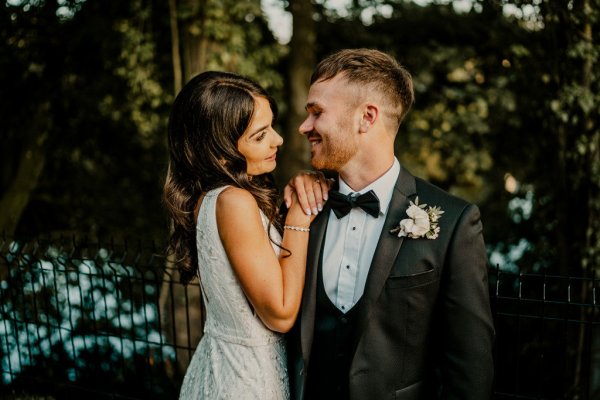 Bride and groom look at each other smile