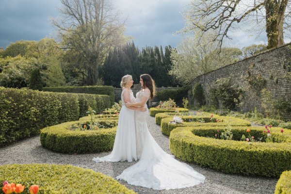 Brides wives close on path holding sunflowers bouquet garden hug