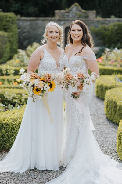 Brides wives close on path holding sunflowers bouquet garden