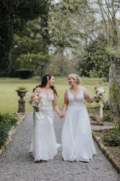 Brides wives close on path holding sunflowers bouquet garden