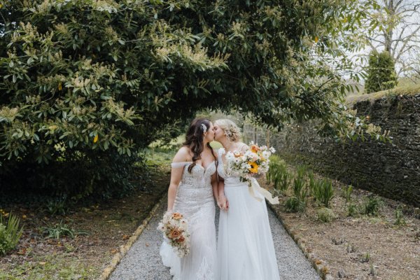 Brides wives close on path holding sunflowers bouquet garden