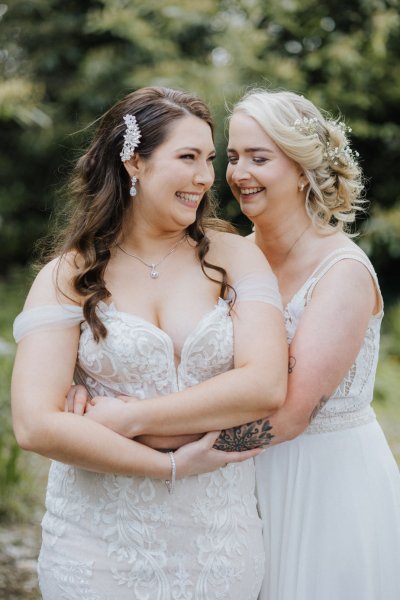 Brides embrace hug and hold each others arms