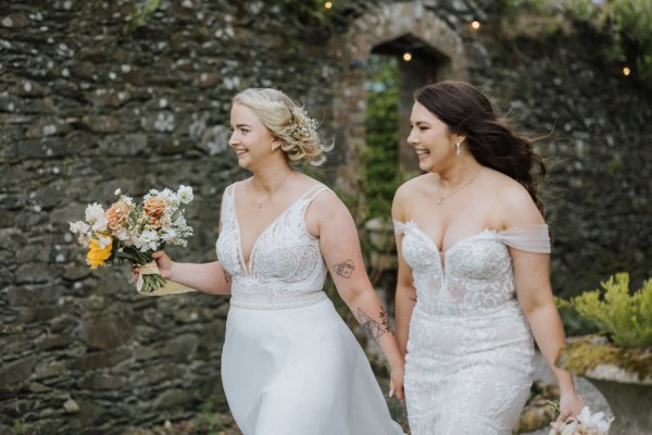 Brides walking holding flowers hand in hand