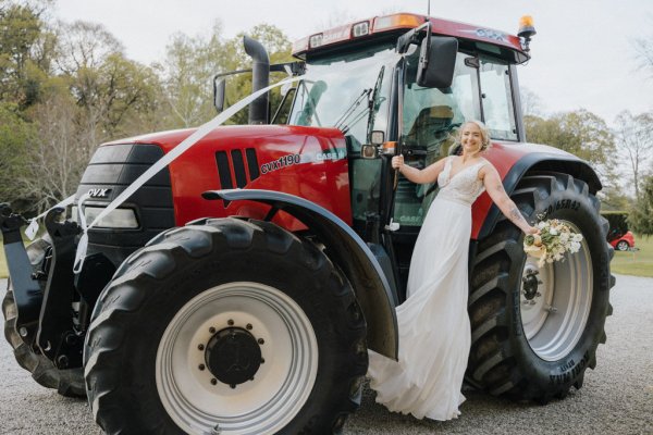 Brides wives red tractor with flowers on the wheel