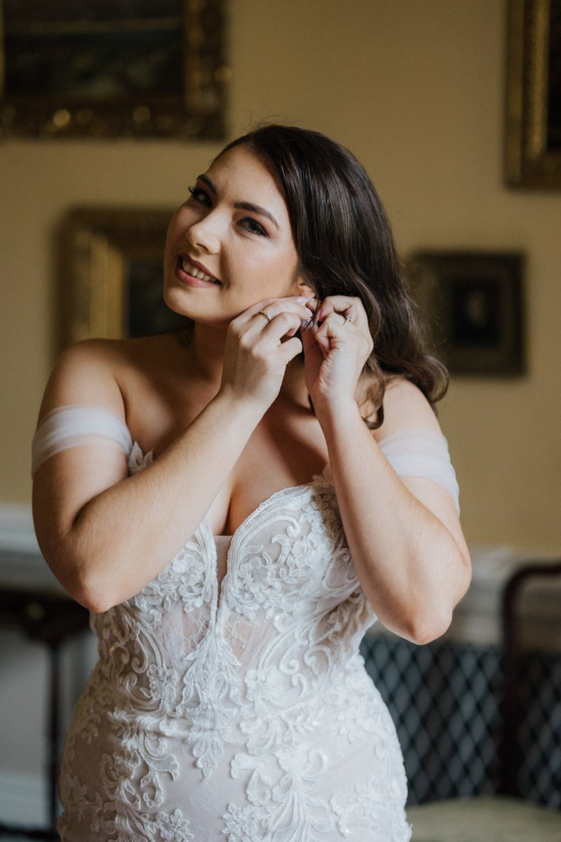 Bride puts on earrings