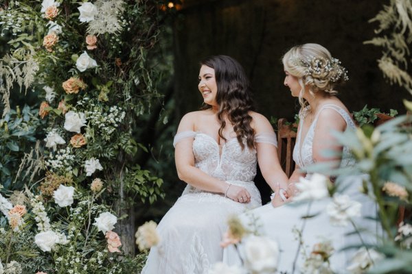 Close up of brides dress flowers surrounding them wives