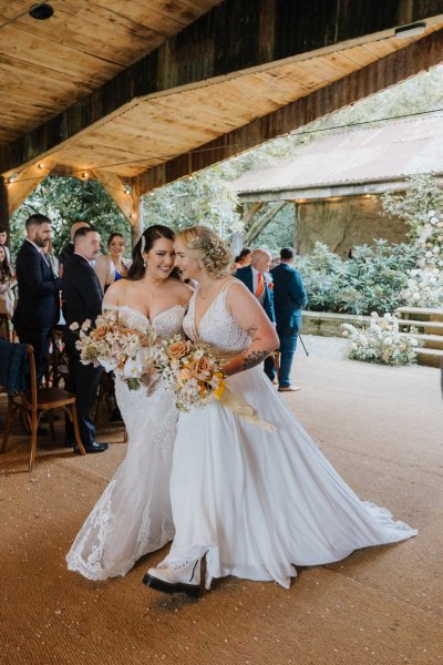 Brides wives exiting wedding ceremony holding hands