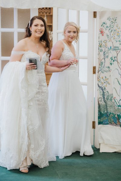 Brides in dining room together holding hands