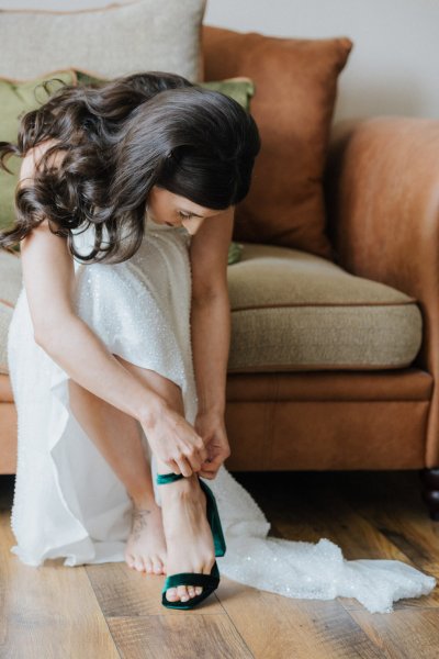 Bride putting on bridal heels shoes