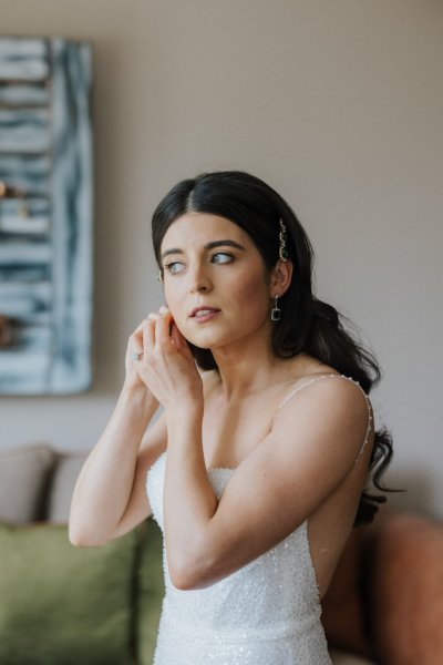 Bride putting on earrings