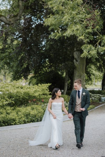 Bride and groom exterior forest park hand in hand