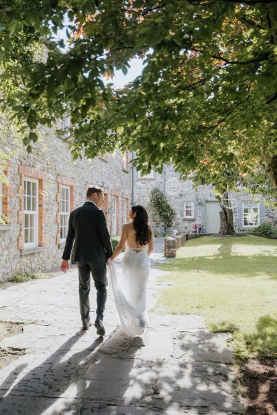 Sun is shining as bride and groom walk hand in hand