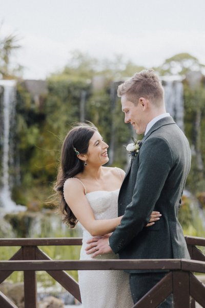 Bride and groom embrace on bridge