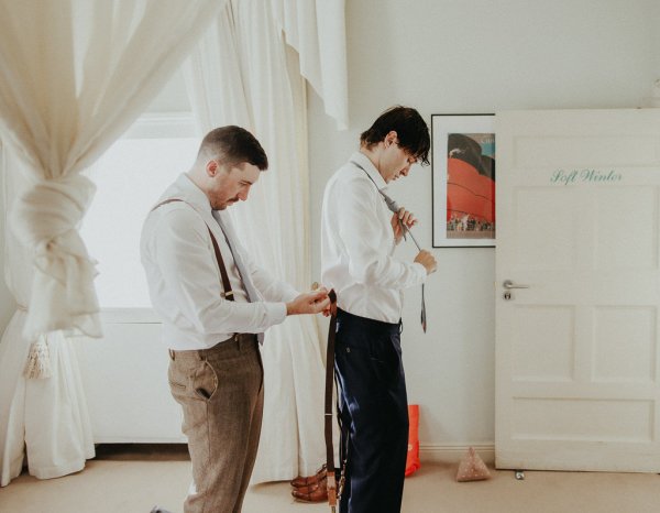 Groomsman helps groom get ready